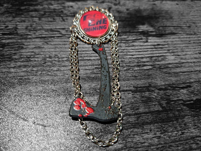 Ornate brooch with chains and blooded axe ,The shining inspired