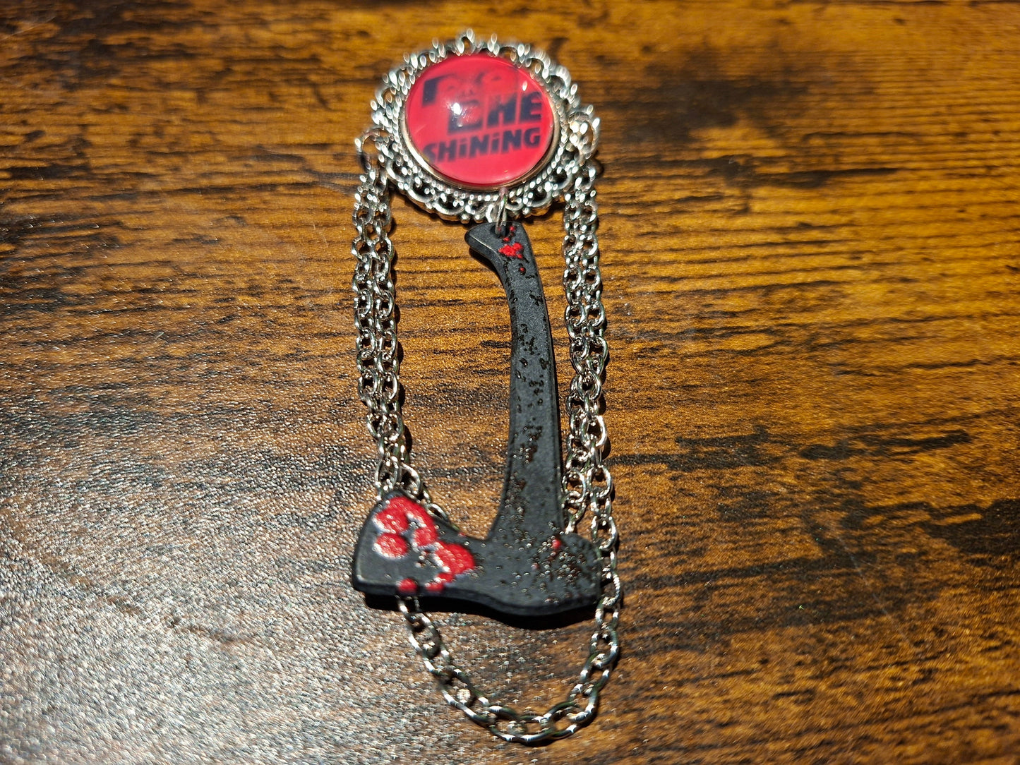 Ornate brooch with chains and blooded axe ,The shining inspired