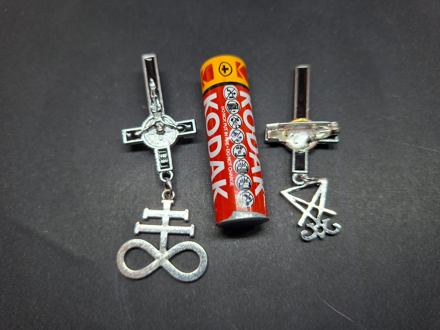 Inverted metal crucifix pin badge with satanic sigils
