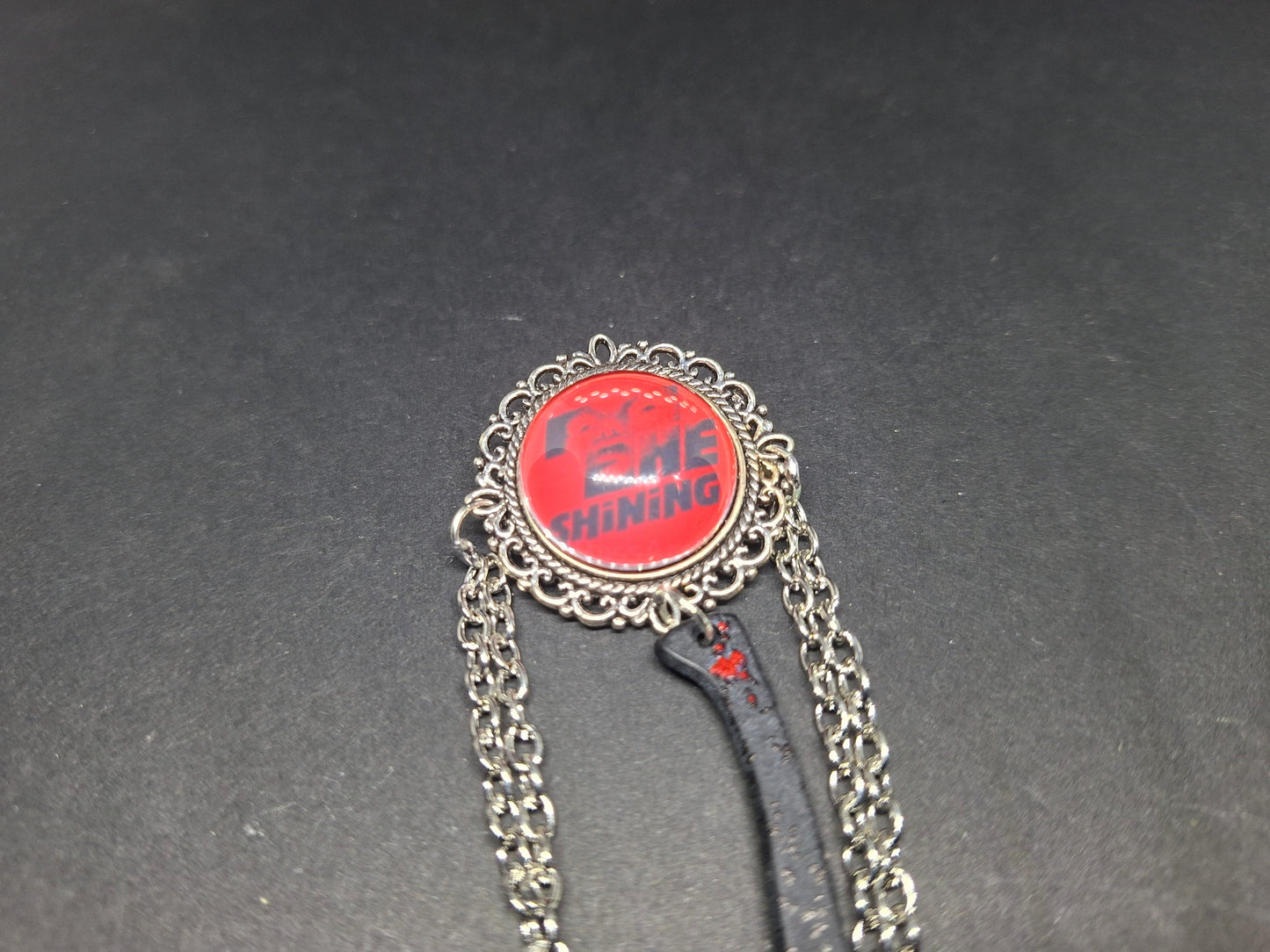 Ornate brooch with chains and blooded axe ,The shining inspired