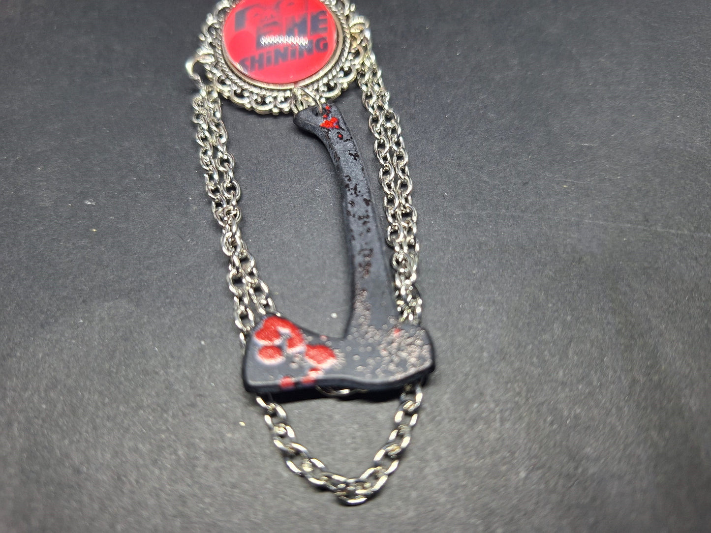 Ornate brooch with chains and blooded axe ,The shining inspired