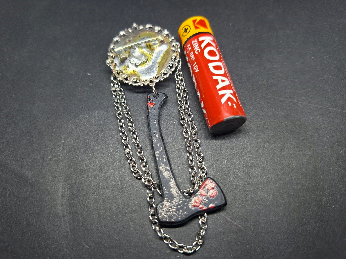 Ornate brooch with chains and blooded axe ,The shining inspired
