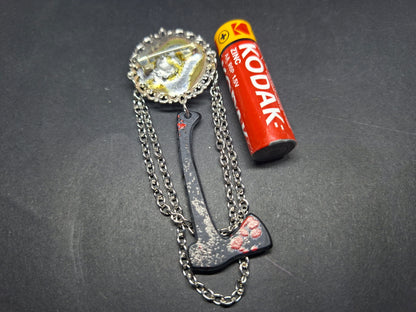 Ornate brooch with chains and blooded axe ,The shining inspired